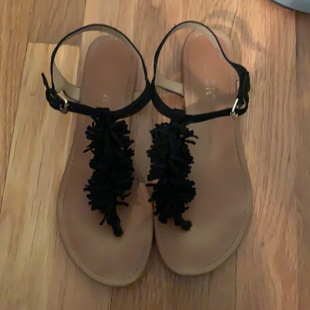 Report brand. Black fringe sandal with tan sole.
